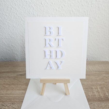 Carte d’anniversaire artisanale blanche minimaliste avec texte BIRTHDAY en relief, créée par Cartes d’Émoi