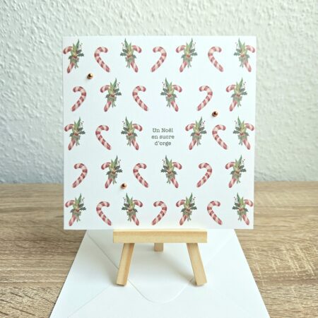 Carte de Noël "Un Noël en sucre d’orge" avec cannes en sucre et feuillage illustrés par @pyokoo_illustration, design Cartes d’émoi, décor doré, fabriquée à la main en Suisse