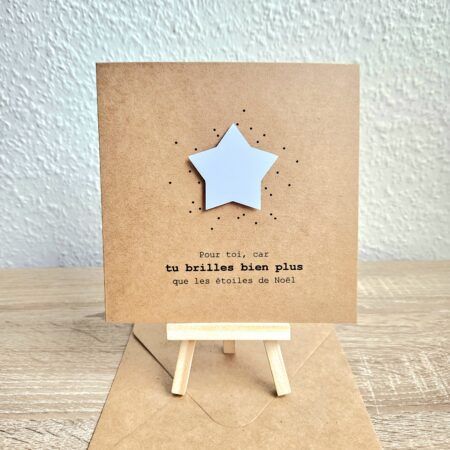 Carte de Noël en papier kraft avec une étoile blanche en relief et le message "Tu brilles bien plus que les étoiles de Noël".