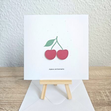 Carte d’anniversaire avec deux cerises rouges en relief et le texte "Joyeux anniversaire".