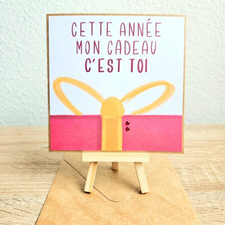 Carte de Noël illustrée avec un cadeau rouge et le message "Cette année mon cadeau c’est toi", finition artisanale Cartes d’émoi.
