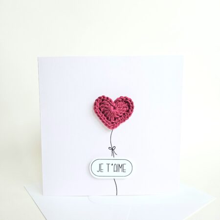 Carte d’amour minimaliste avec coeur rouge bordeaux crocheté à la main en forme de ballon et message "je t’aime", coeur magnet détachable.