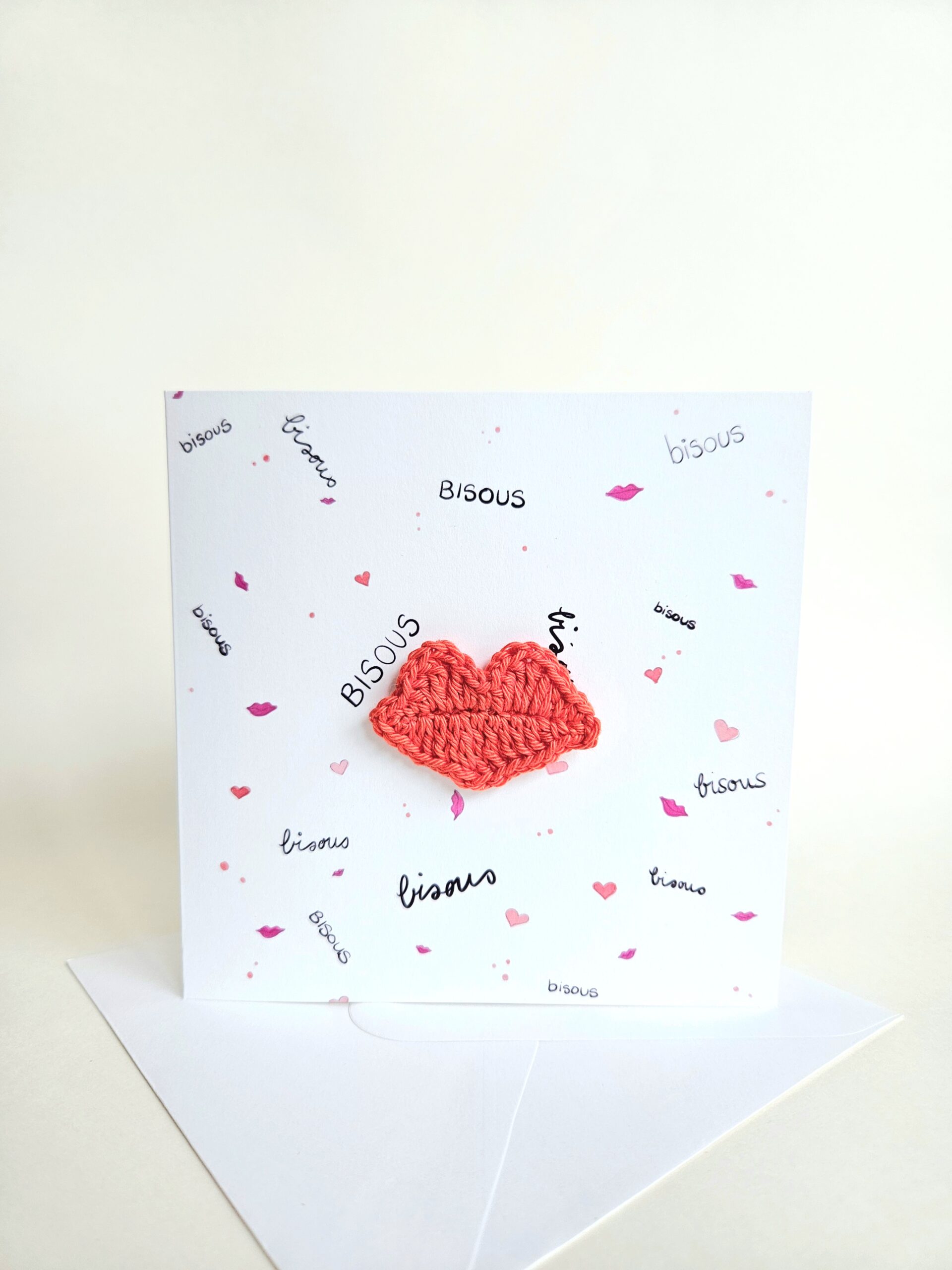 Carte artisanale avec motifs bisous et coeurs, lèvres rouges éclatantes crochetées à la main aimantées et détachables.