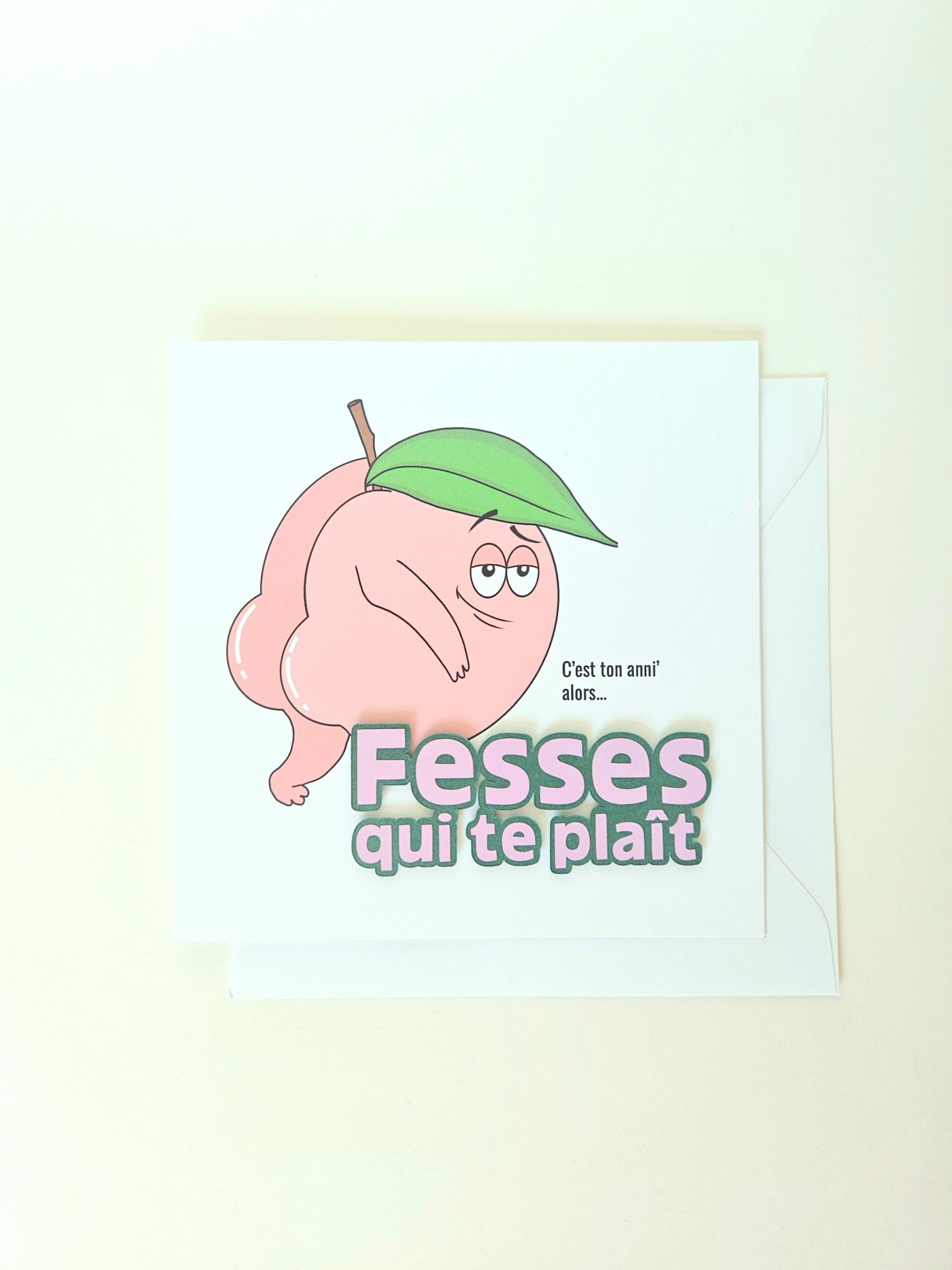 Carte d’anniversaire humoristique avec illustration d’une pêche et message "Fesses qui te plaît". Création artisanale drôle et originale.