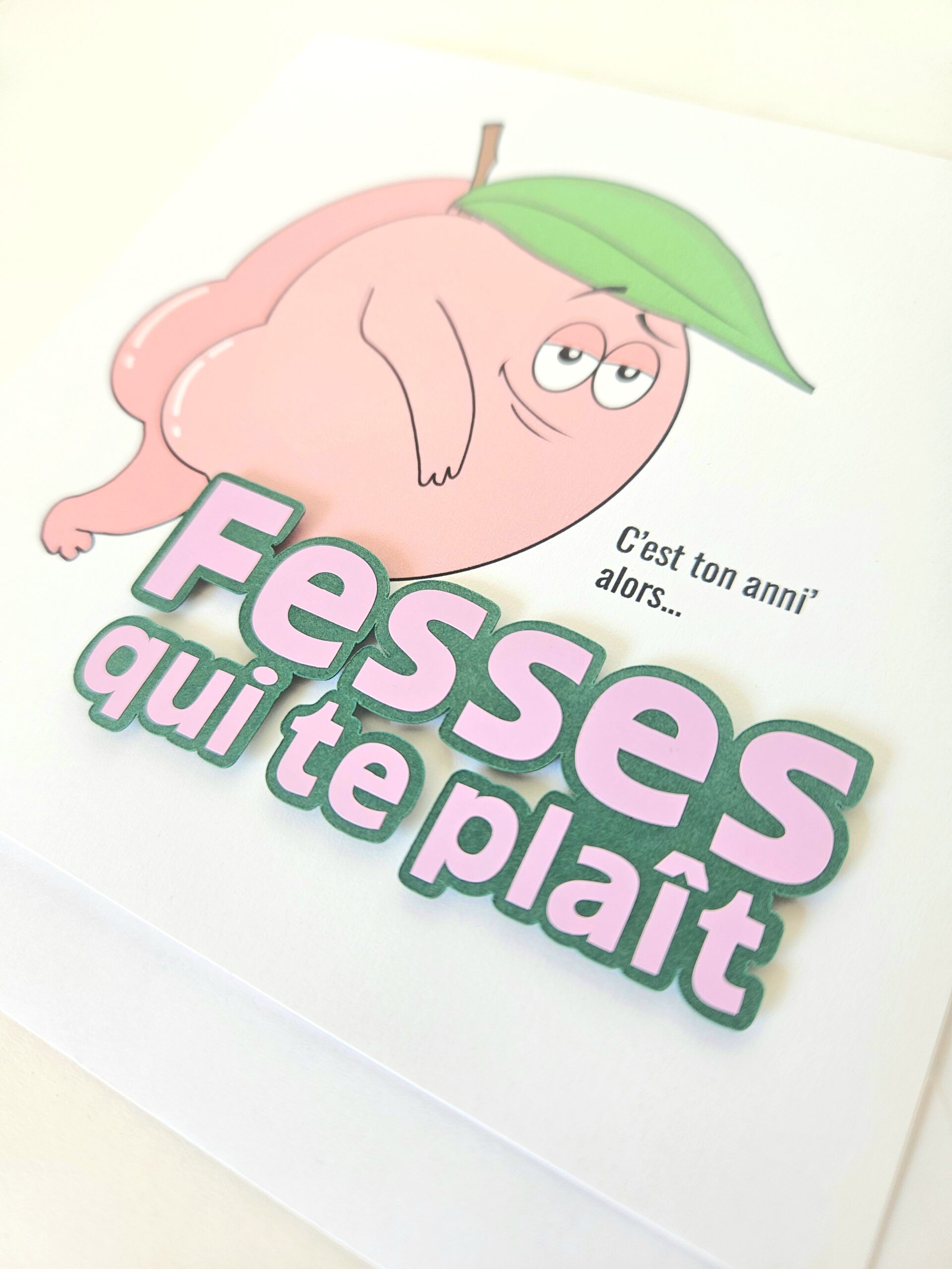 Carte d’anniversaire humoristique avec illustration d’une pêche et message "Fesses qui te plaît". Création artisanale drôle et originale.