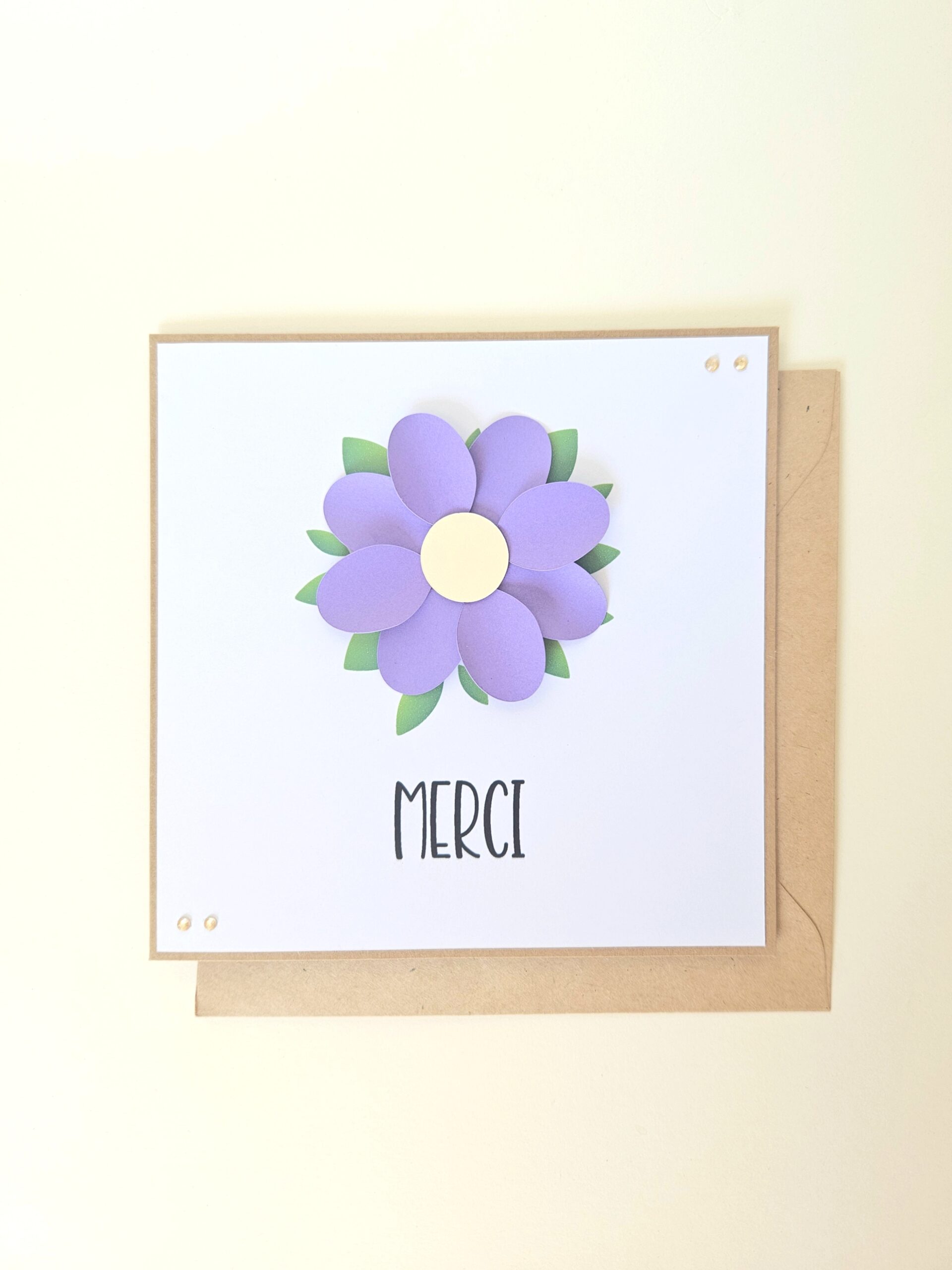 Carte de remerciement artisanale avec fleur violette en relief et message "Merci".