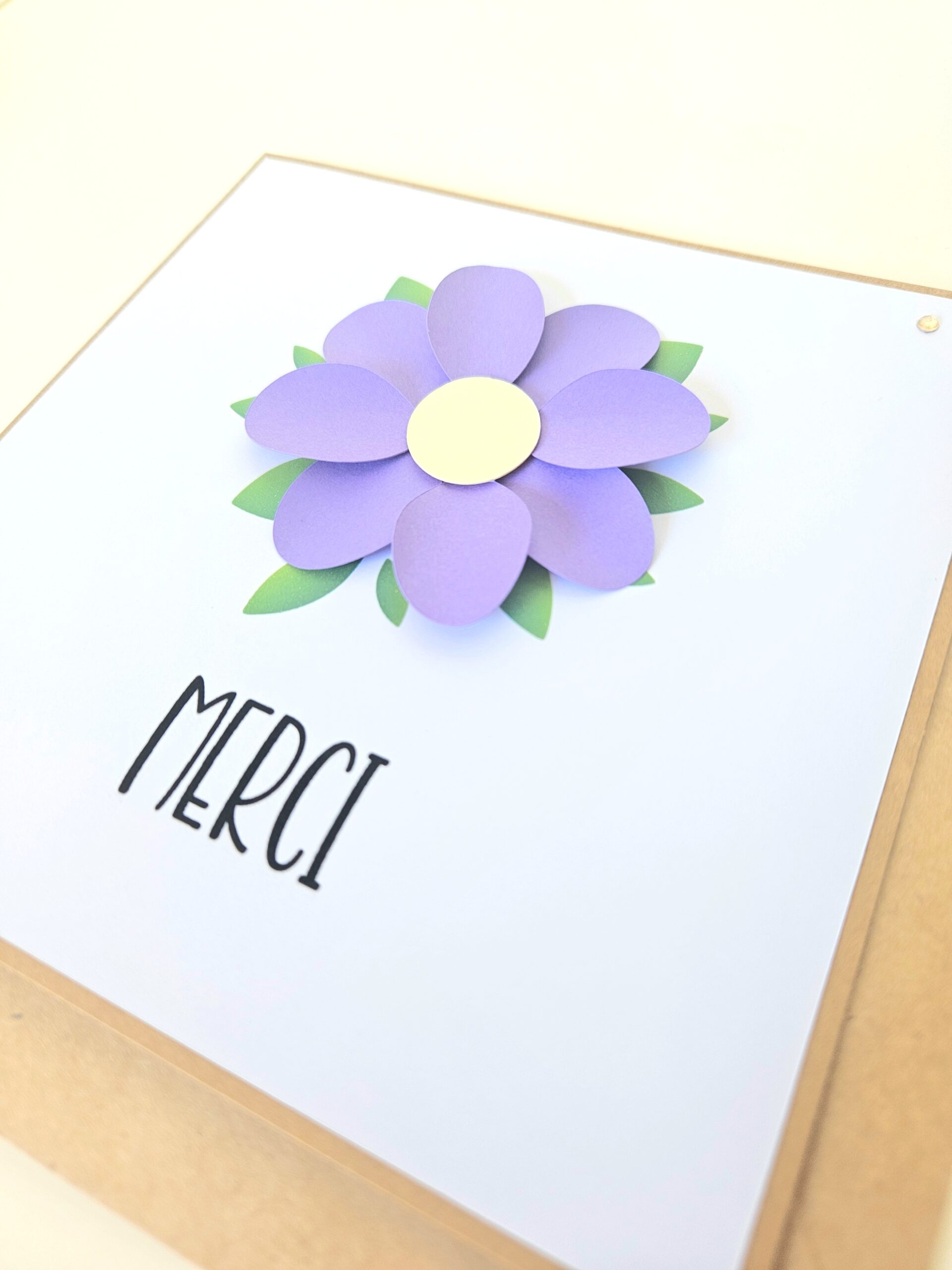 Carte de remerciement artisanale avec fleur violette en relief et message "Merci".