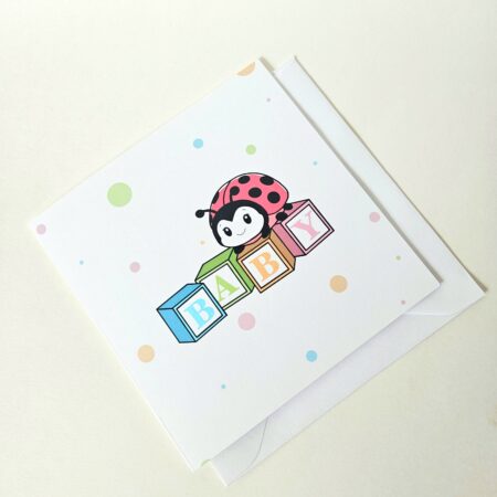 Carte de naissance avec une coccinelle posée sur des cubes colorés formant le mot "Baby", décorée de pois pastel.